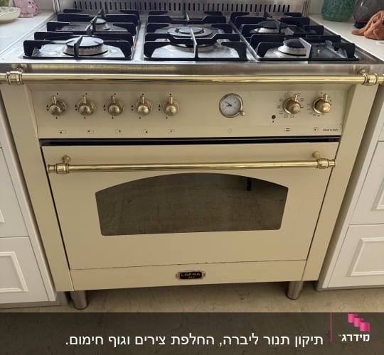 תנור גז עם כפתורים ומד טמפרטורה במטבח